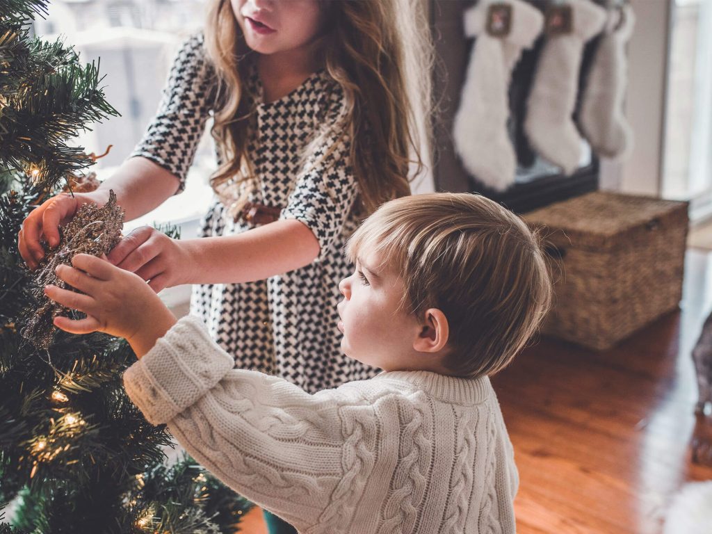 Children putting decorations on Christmas Tree