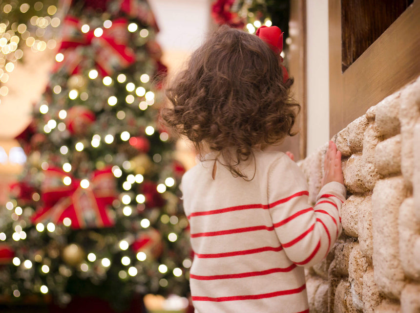 Child Looking at Christmas Tree outdoors