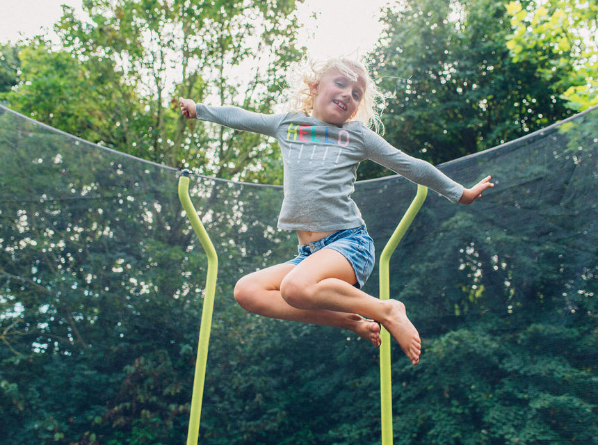 Girl jumping on Plum Play Wave Trampoline